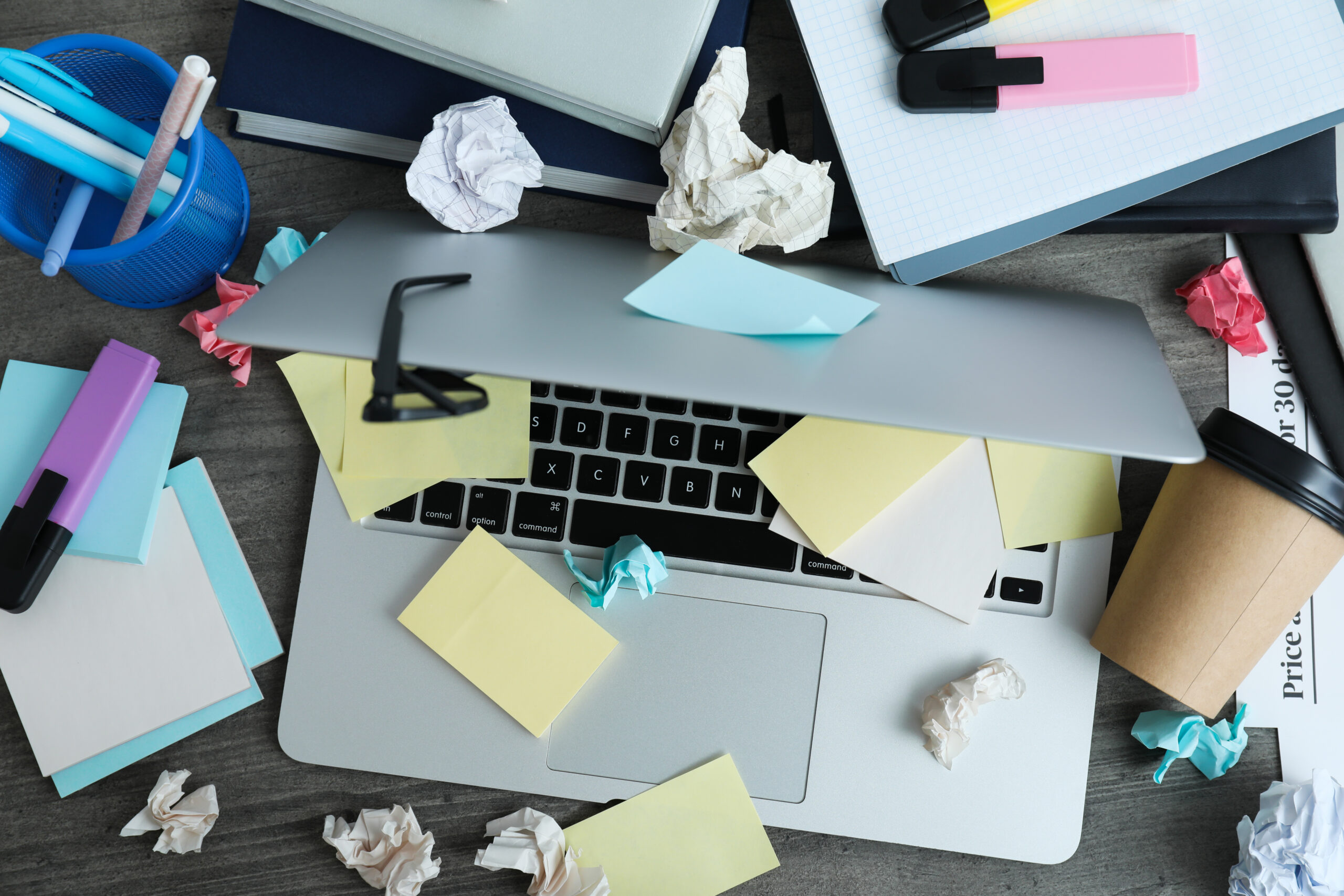 Messy desk with documents and laptop representing real-world AI constraints